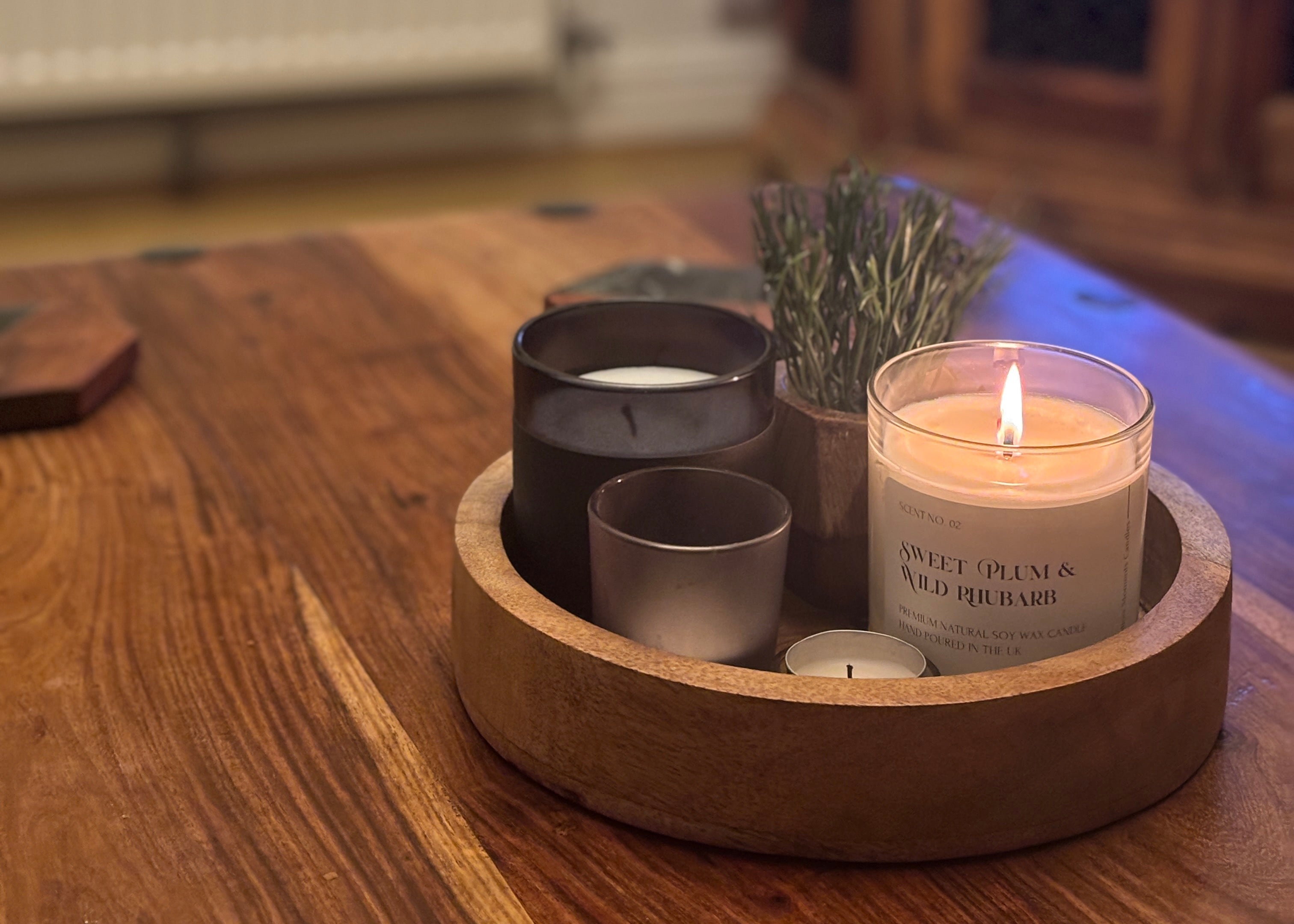 Handmade soy wax candle in a clear container candle glass on a rustic wooden table